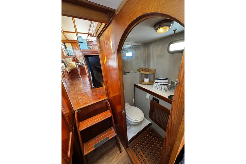 Slide: The Image of 1982 Marine Trader Europa yacht interior with wooden stairs and compact bathroom. - 81