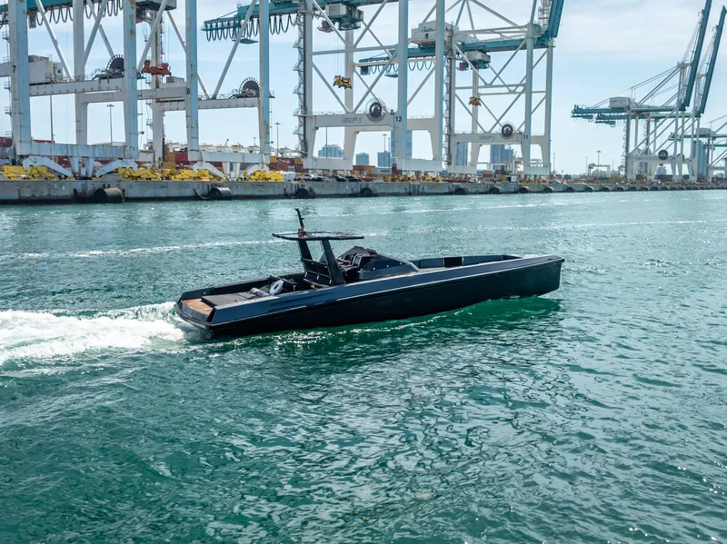 Slide: The Image of Sleek 2012 Wally 43 yacht cruising near industrial port cranes. - 6