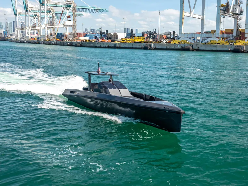 Slide: The Image of Sleek 2012 Wally 43 yacht cruising in a busy harbor with industrial backdrop. - 7
