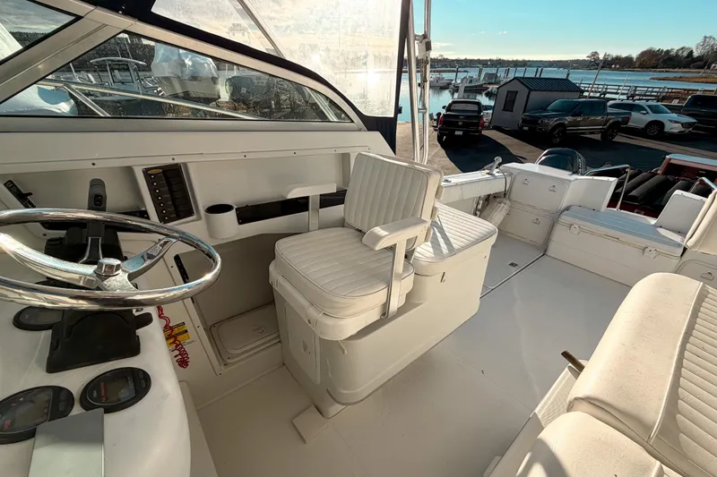 Slide: The Image of 2004 Glacier Bay 2670 Isle Runner boat interior with steering wheel and seating. - 10