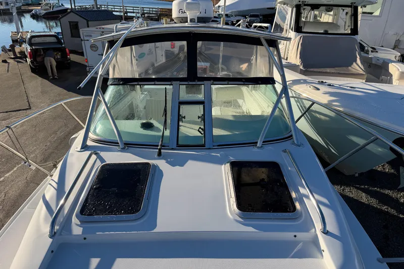 Slide: The Image of 2004 Glacier Bay 2670 Isle Runner boat docked at marina, front view. - 14