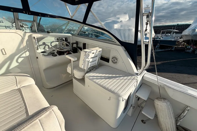 Slide: The Image of 2004 Glacier Bay 2670 Isle Runner boat interior with helm and seating area. - 8