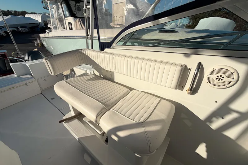 Slide: The Image of 2004 Glacier Bay 2670 Isle Runner boat interior with white seating and speaker. - 9
