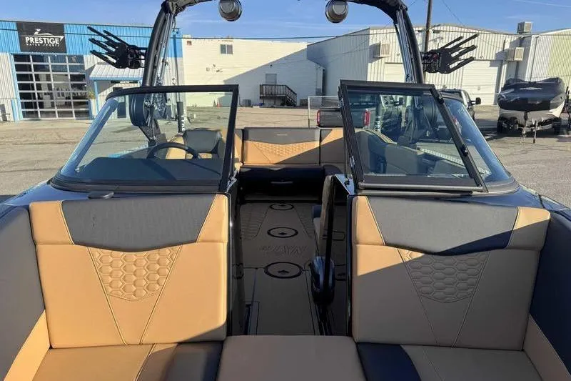 Slide: The Image of 2026 MasterCraft NXT23 boat interior with tan and black seating, modern dashboard, and spacious layout. - 11