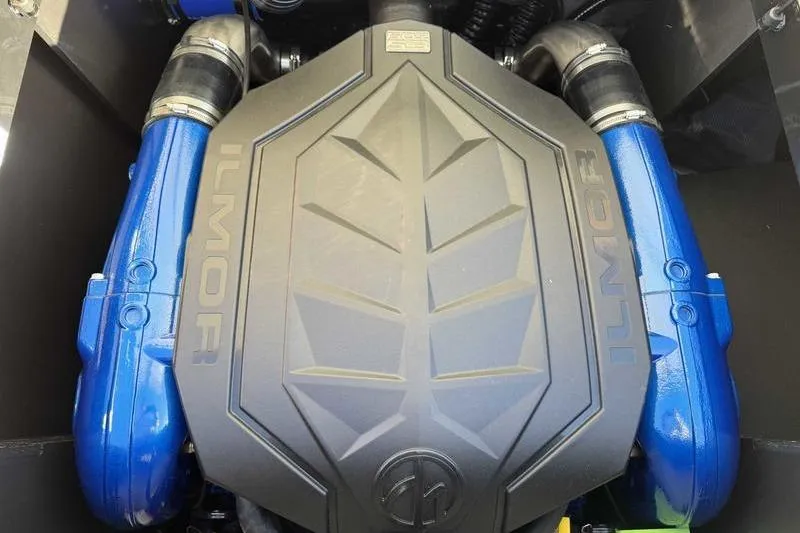 Slide: The Image of 2026 MasterCraft NXT23 boat interior with tan and gray seating, docked outdoors. - 12