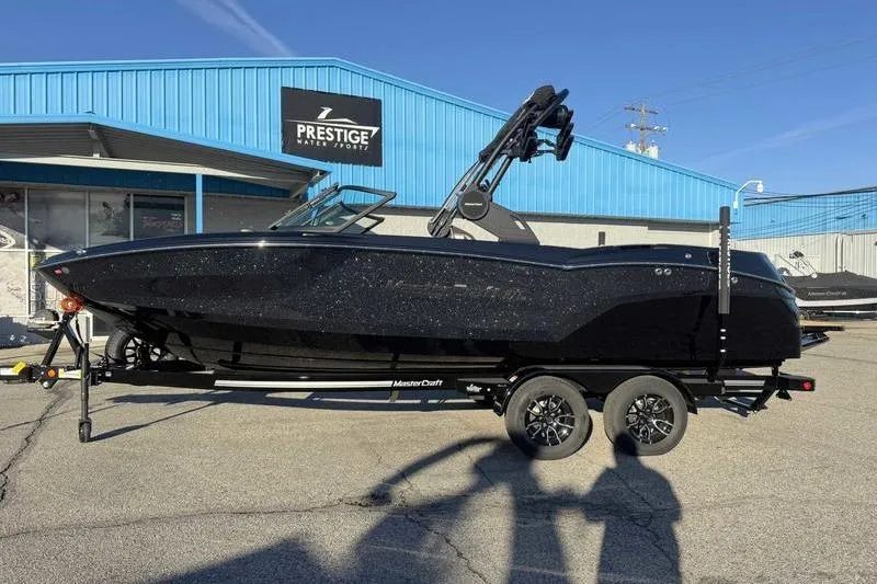 Slide: The Image of 2026 MasterCraft NXT23 boat interior with tan and black seating, open bow design. - 14