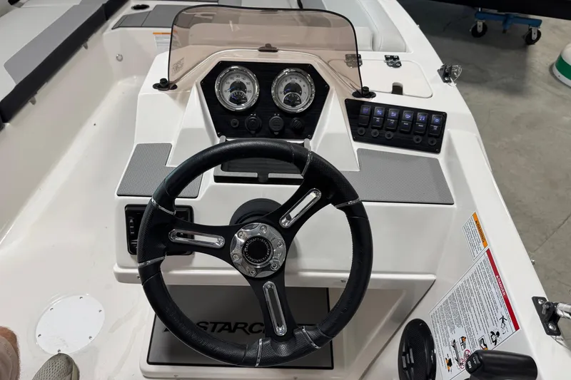 Slide: The Image of 2026 Starcraft SV 16 OB boat dashboard with steering wheel and control panel. - 17