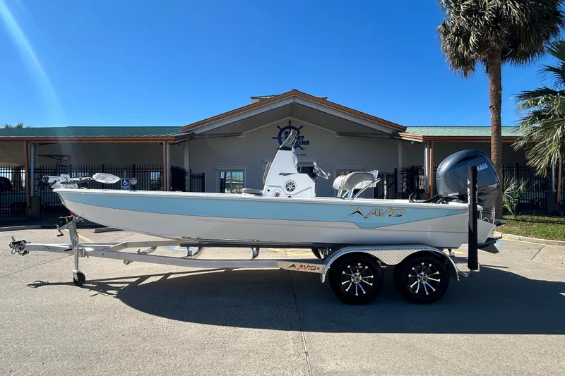 The Image of 2025 Avid 21 FST boat on trailer, parked outdoors under clear blue sky. - 0