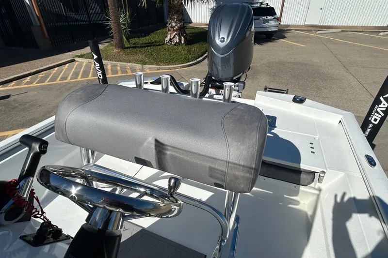 Slide: The Image of Avid 21 FST 2025 boat interior with steering wheel and motor in a parking lot. - 13