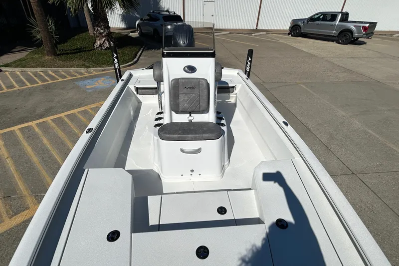 Slide: The Image of Avid 21 FST 2025 boat interior with seating and console in a parking lot. - 17