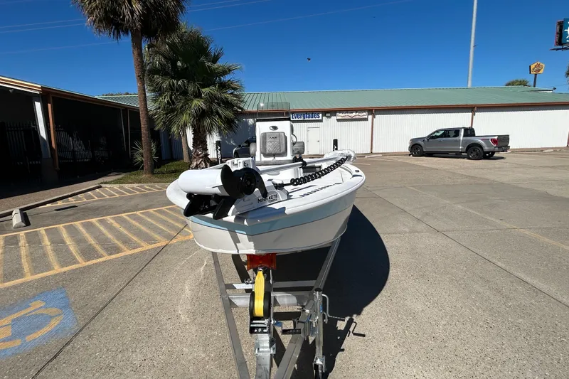 Slide: The Image of 2025 Avid 21 FST boat on trailer in parking lot, palm tree nearby. - 6
