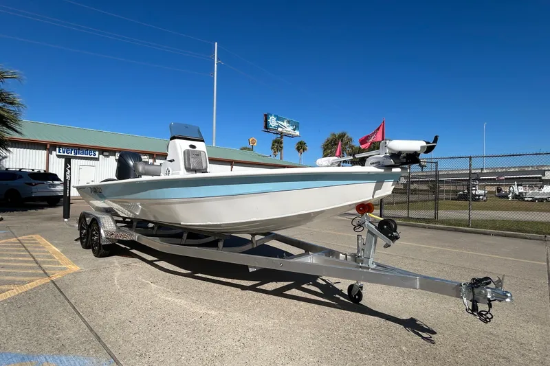 Slide: The Image of 2025 Avid 21 FST boat on trailer, parked outdoors under clear blue sky. - 7