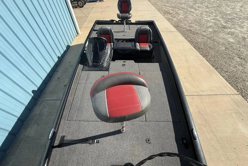 Slide: The Image of 2018 Ranger RT198P fishing boat with red and gray seating, parked near a blue building. - 22