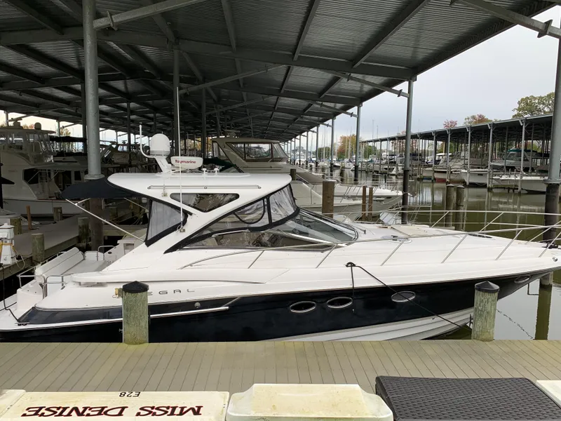 The Image of 2009 Regal 4460 yacht docked in a covered marina. - 0