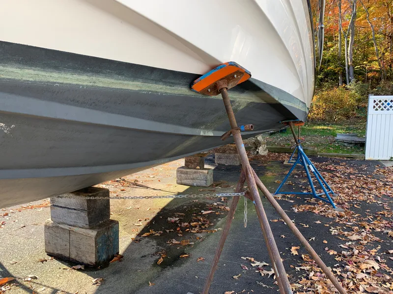 Slide: The Image of 2009 Regal 4460 boat on stands for maintenance, autumn leaves on ground. - 10