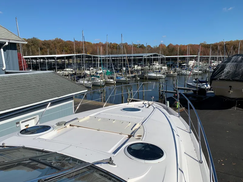 Slide: The Image of 2009 Regal 4460 yacht docked at a marina with sailboats in the background. - 20