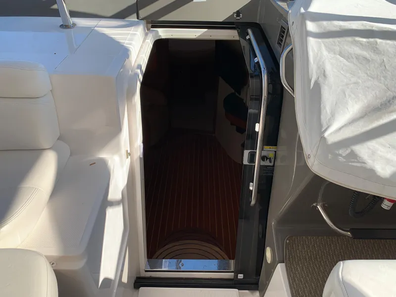 Slide: The Image of 2009 Regal 4460 yacht cabin entrance with white seating and wooden flooring. - 30