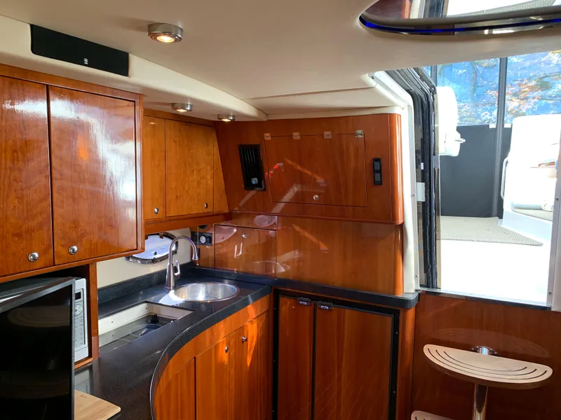 Slide: The Image of Luxurious kitchen area in a 2009 Regal 4460 yacht with wooden cabinetry and modern amenities. - 34