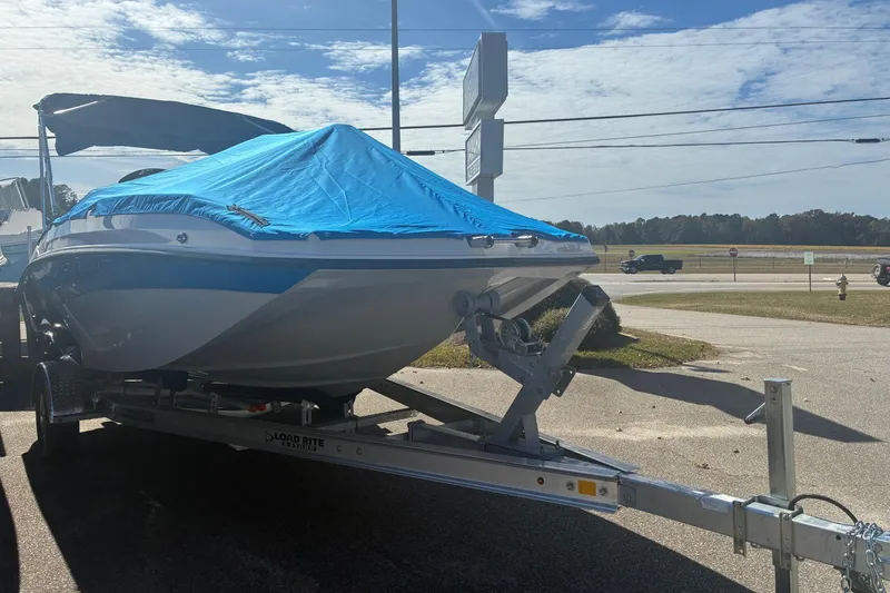 Slide: The Image of 2026 Starcraft SVX 171 OB boat on trailer, covered with blue tarp, parked outdoors. - 7