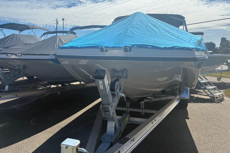Slide: The Image of 2026 Starcraft SVX 171 OB boat covered with blue tarp on trailer, parked outdoors. - 8