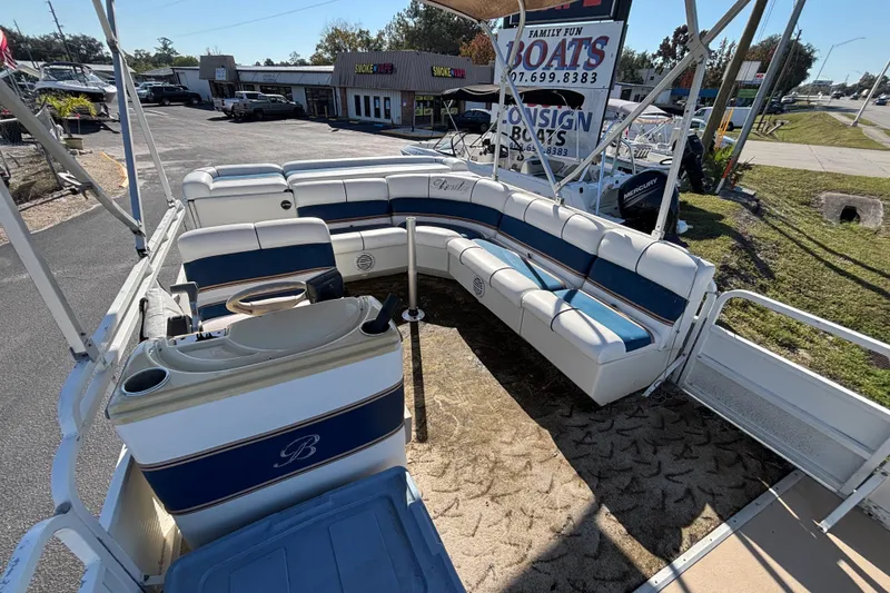 Slide: The Image of 2005 Bentley Pontoons 200 Fish interior with blue and white seating, parked outdoors. - 51