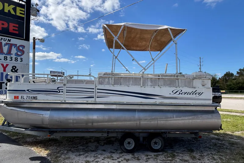 Slide: The Image of 2005 Bentley Pontoons 200 Fish on trailer, featuring canopy and Suzuki outboard motor. - 7