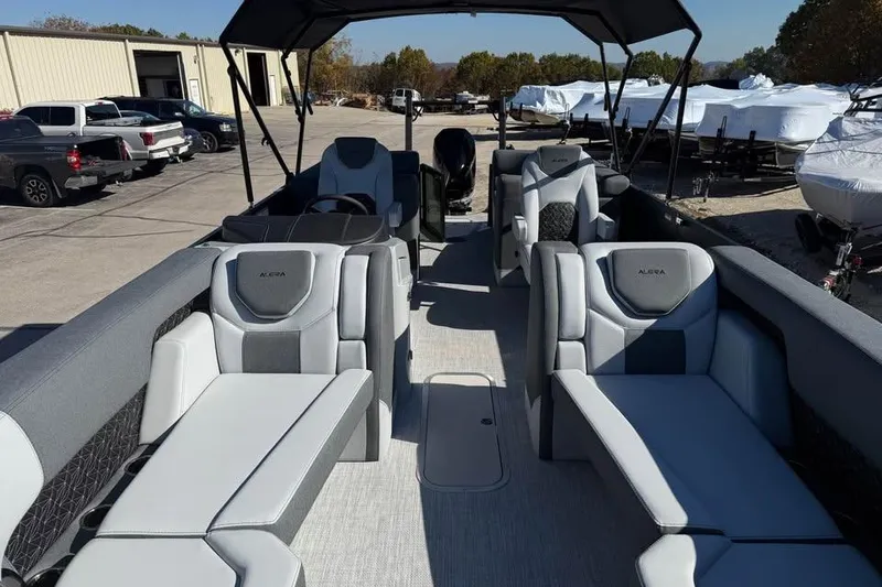Slide: The Image of 2026 Alera M 25Q boat interior with modern seating and canopy in a marina setting. - 13