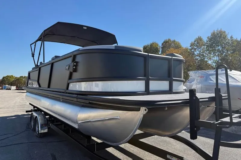 Slide: The Image of 2026 Alera M 25Q pontoon boat on trailer under clear blue sky. - 3