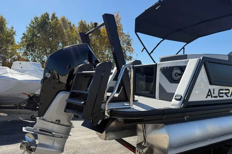 Slide: The Image of Alera M 25Q 2026 pontoon boat with outboard motor and canopy, parked outdoors. - 5