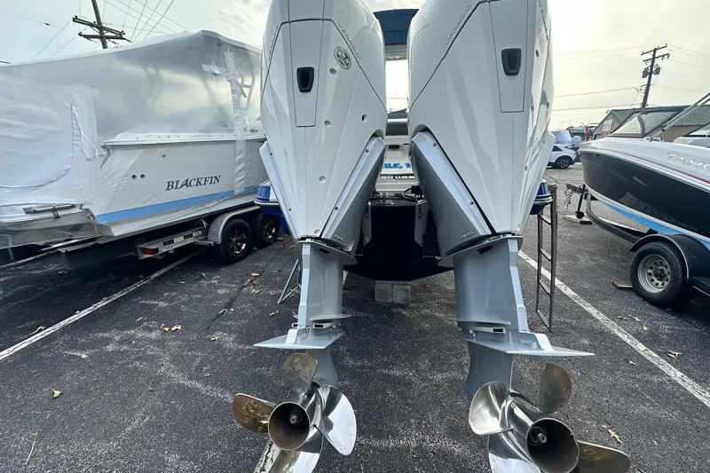 Slide: The Image of 2019 Monterey 305SS Super Sport with dual outboard engines in a marina parking lot. - 12
