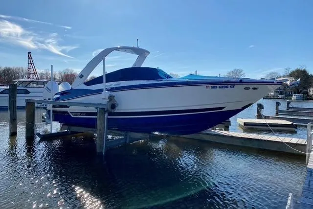 Slide: The Image of 2019 Monterey 305SS Super Sport boat docked near a waterfront building. - 2