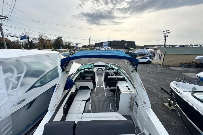 Slide: The Image of 2019 Monterey 305SS Super Sport boat with blue canopy in a marina setting. - 22