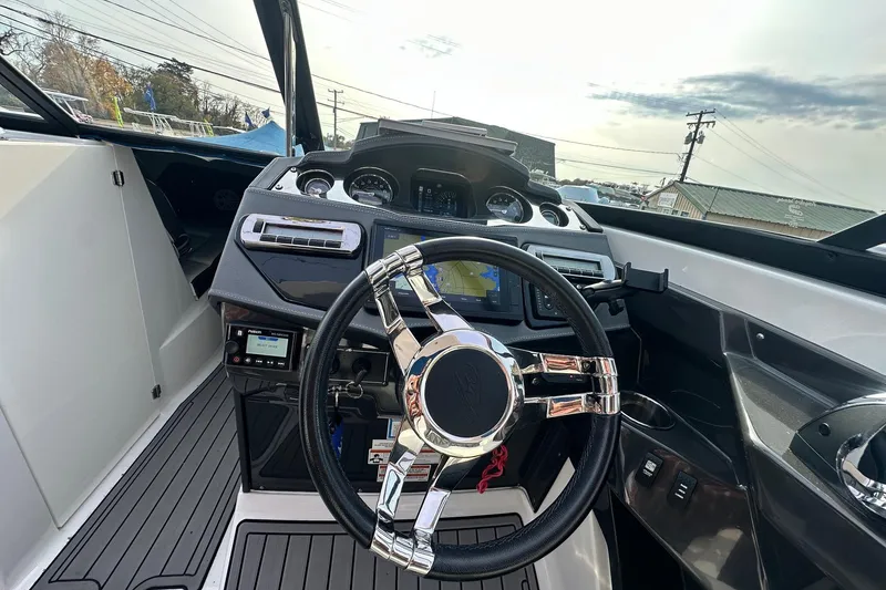 Slide: The Image of 2019 Monterey 305SS Super Sport boat dashboard with steering wheel and navigation controls. - 33