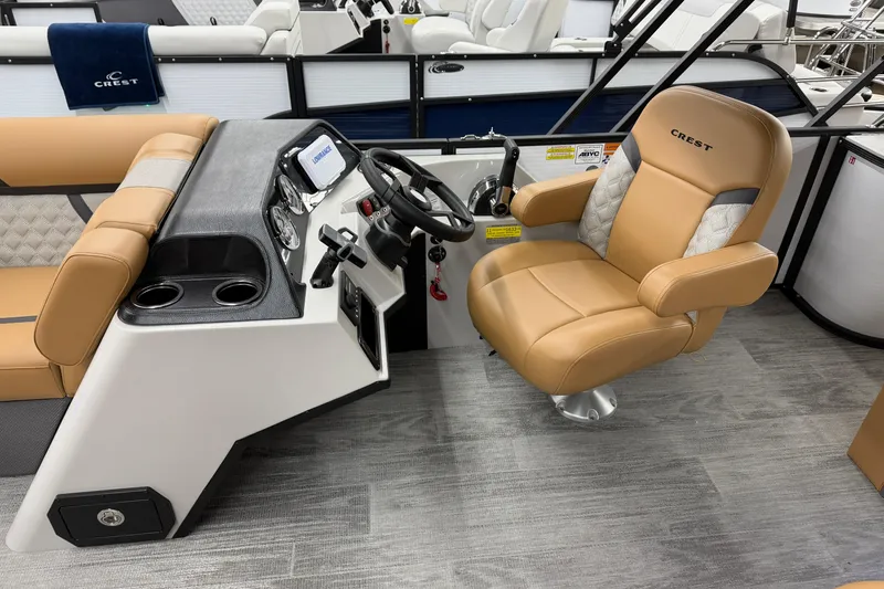 Slide: The Image of 2025 Crest Classic 220 boat interior with tan captain's chair and modern dashboard. - 6