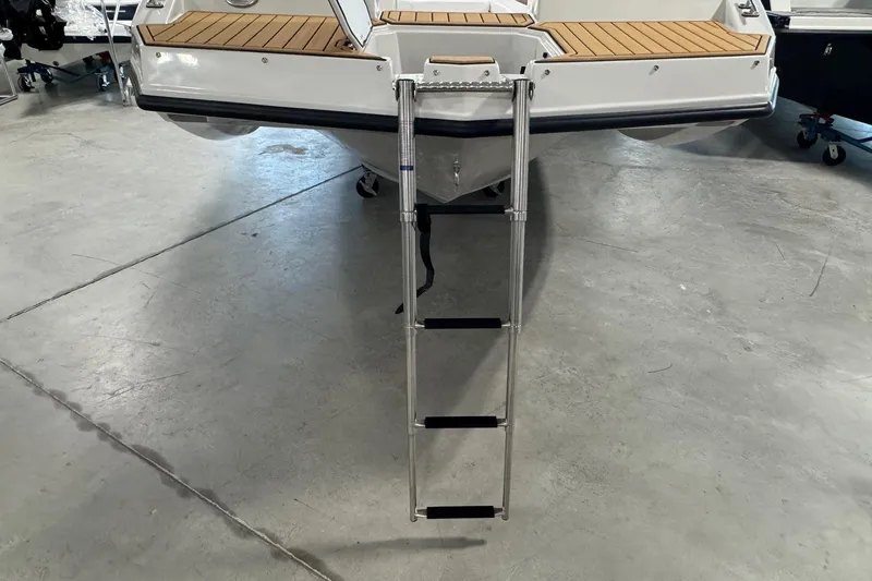Slide: The Image of 2025 Starcraft SVX 171 OB boat with extended swim ladder in a showroom. - 4
