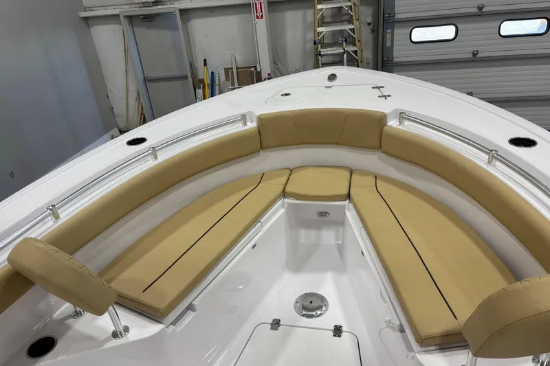 Slide: The Image of 2025 Sportsman Open 212 Center Console boat with tan cushioned seating in a garage. - 3
