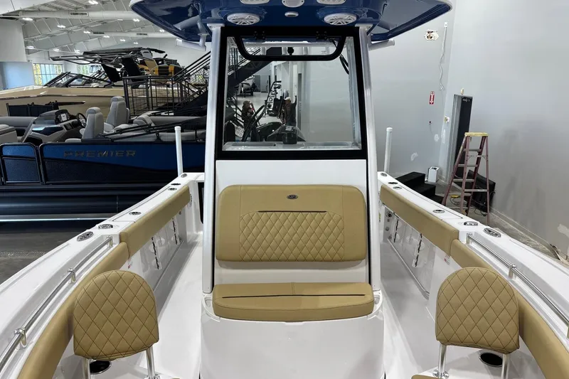 Slide: The Image of 2025 Sportsman Open 212 Center Console boat interior with tan seating in showroom. - 4