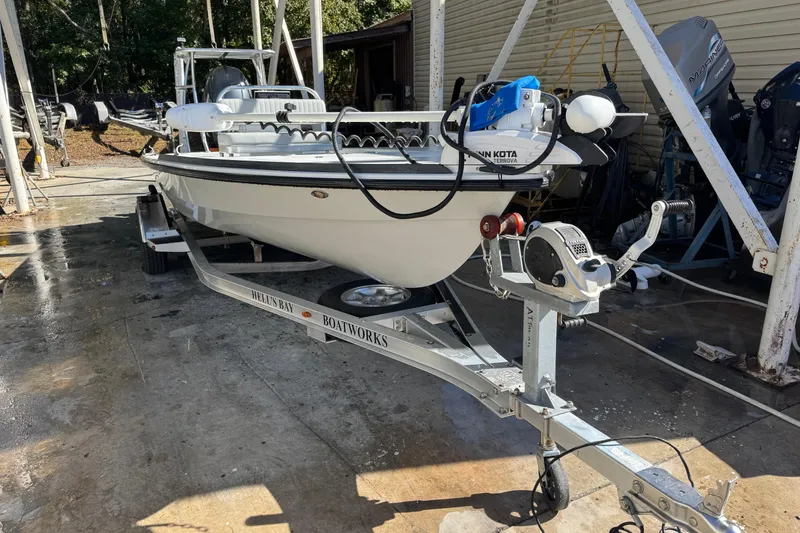 Slide: The Image of 2020 Hell's Bay Marquesa boat on trailer, parked outdoors near a workshop. - 1
