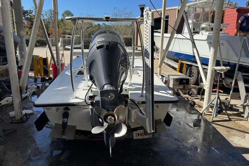 Slide: The Image of 2020 Hell's Bay Marquesa boat in a maintenance area, rear view with motor. - 5