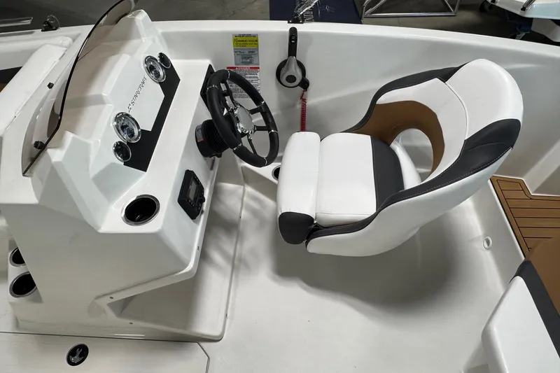 Slide: The Image of 2025 Starcraft SVX 171 OB boat interior with steering console and cushioned captain's chair. - 10