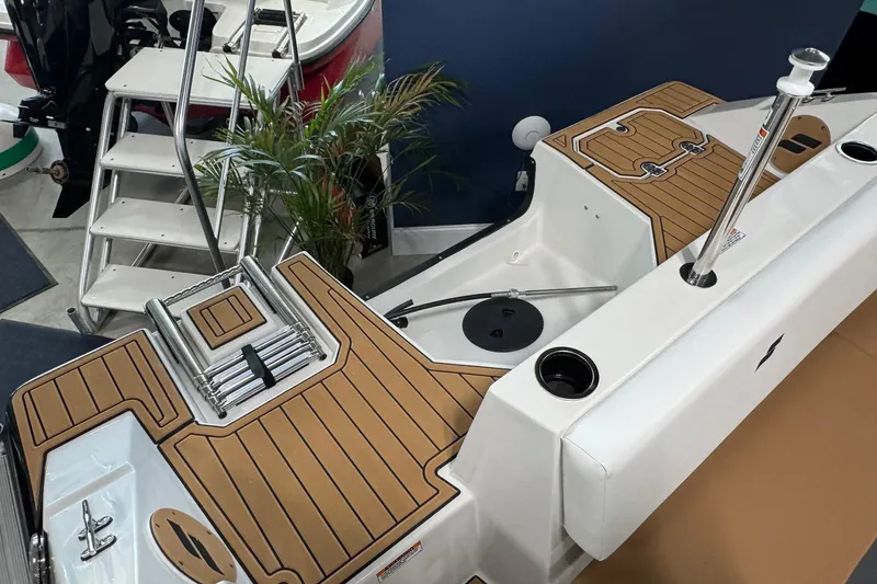 Slide: The Image of 2025 Starcraft SVX 171 OB boat with teak-style decking and stainless steel ladder. - 13