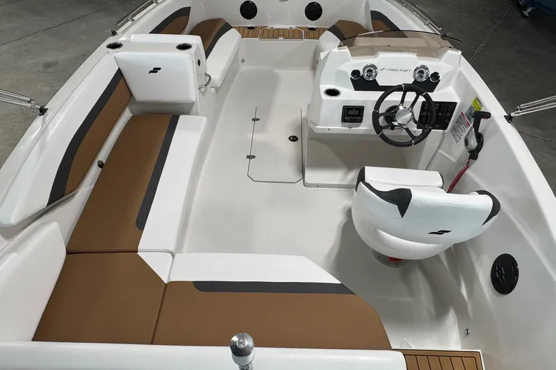 Slide: The Image of 2025 Starcraft SVX 171 OB boat interior with brown and white seating, steering console, and modern design. - 14