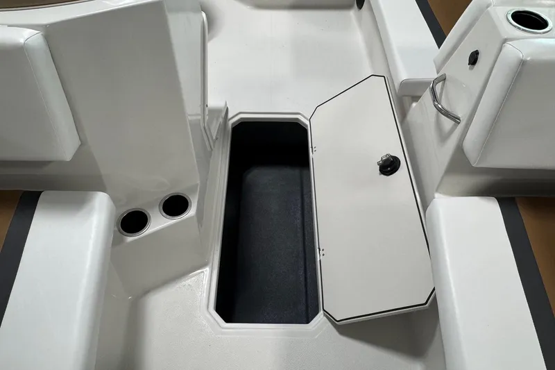 Slide: The Image of 2025 Starcraft SVX 171 OB boat interior with open storage compartment and cup holders. - 9