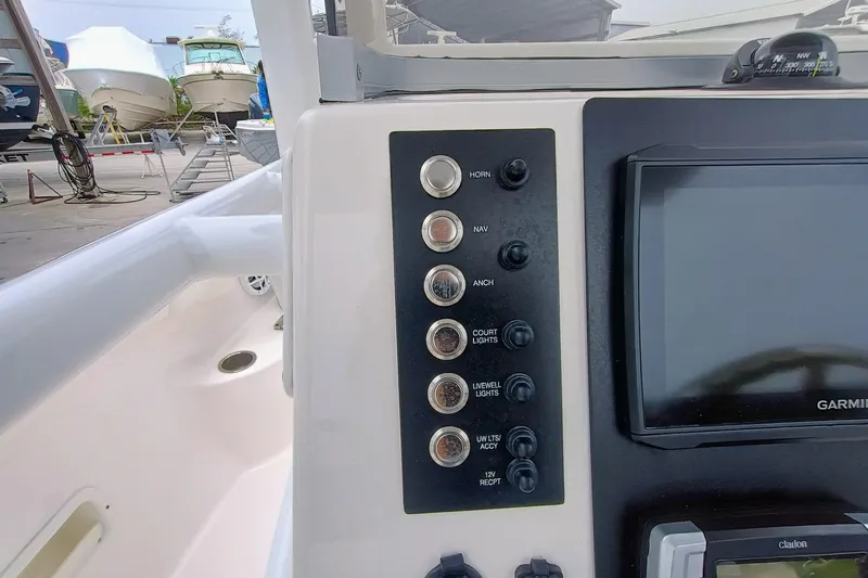 Slide: The Image of Control panel of 2023 Robalo R222 Center Console boat with switches and Garmin display. - 14