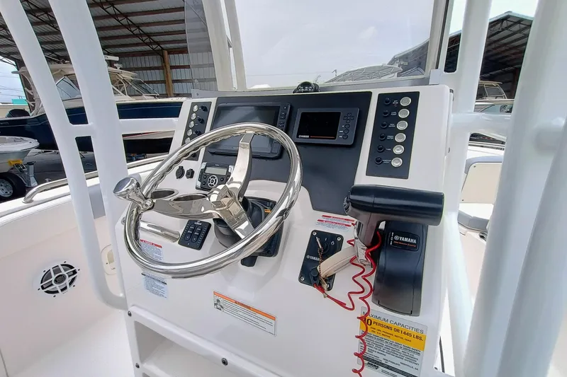Slide: The Image of 2023 Robalo R222 Center Console boat dashboard with steering wheel and controls. - 15