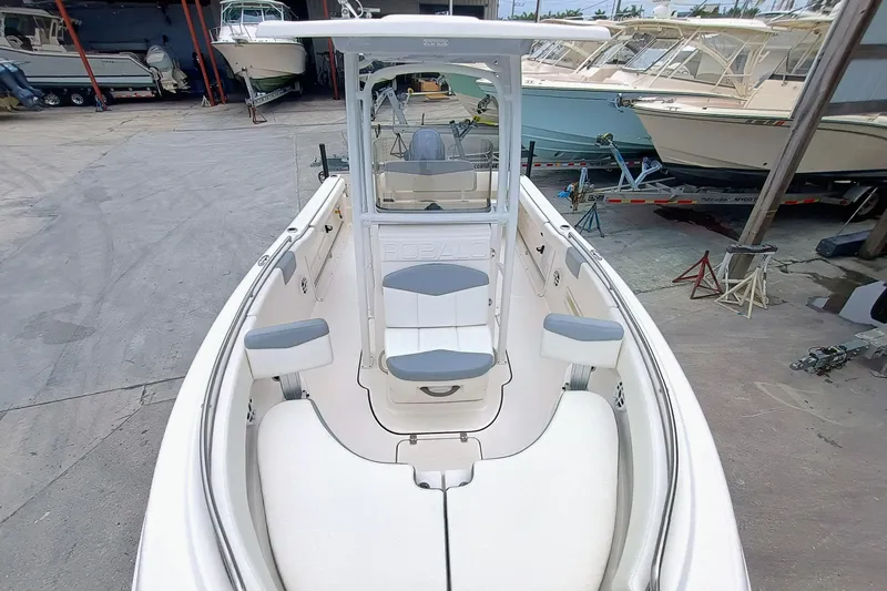 Slide: The Image of 2023 Robalo R222 Center Console boat with spacious seating, docked in a marina. - 18