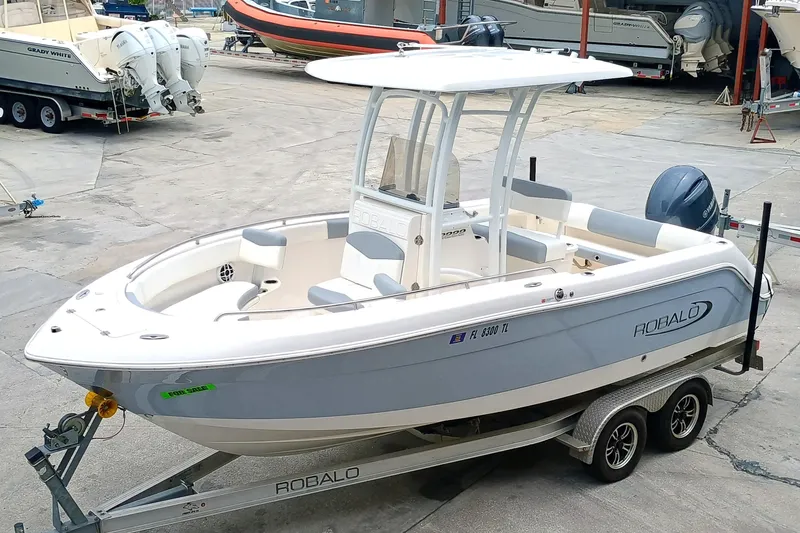 Slide: The Image of 2023 Robalo R222 Center Console boat on trailer in marina setting. - 4