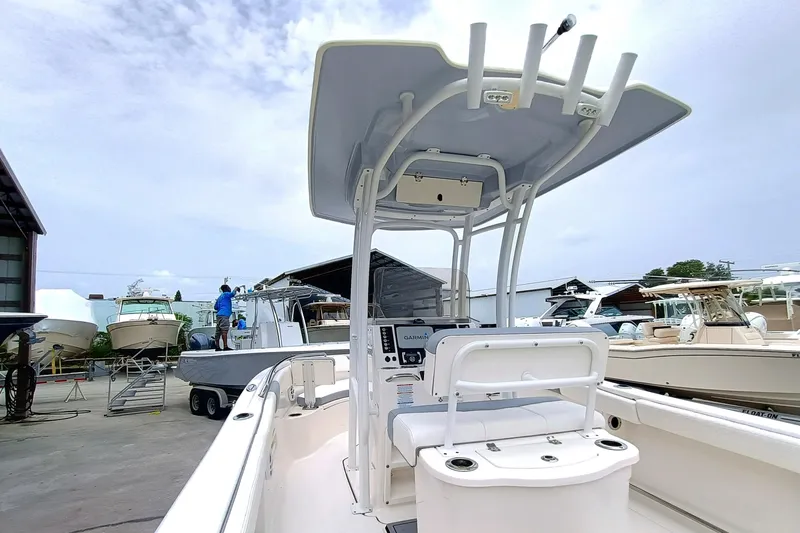 Slide: The Image of 2023 Robalo R222 Center Console boat in a marina, showcasing helm and seating area. - 8