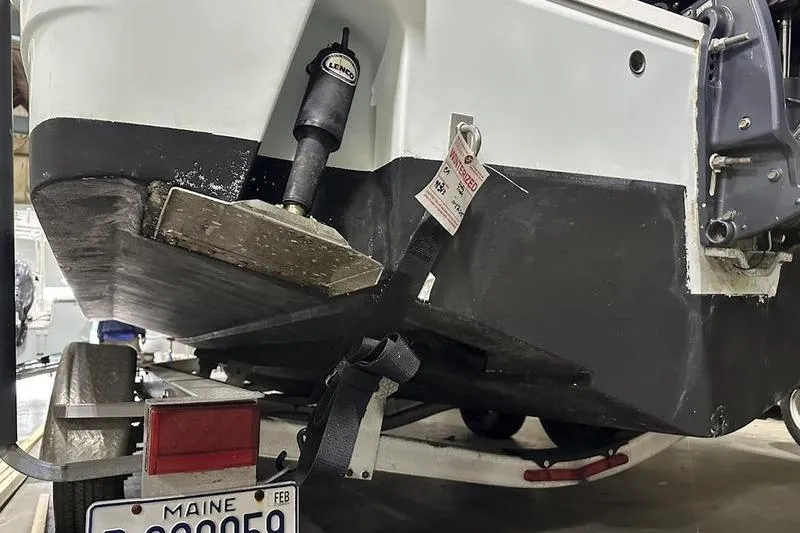 Slide: The Image of 2018 Robalo R242 Explorer boat on trailer, showing hull and propeller details. - 12