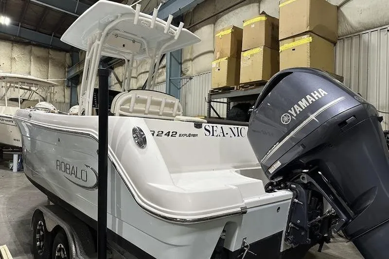 Slide: The Image of 2018 Robalo R242 Explorer boat in a showroom, showcasing sleek design and branding. - 6